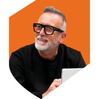 A man wearing glasses with a black top, short hair and beard sitting with an orange background in the shape of a shield.